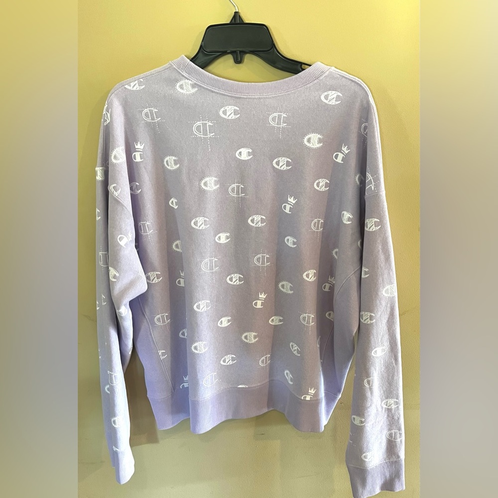 Light purple Champion Crewneck with all over logo.